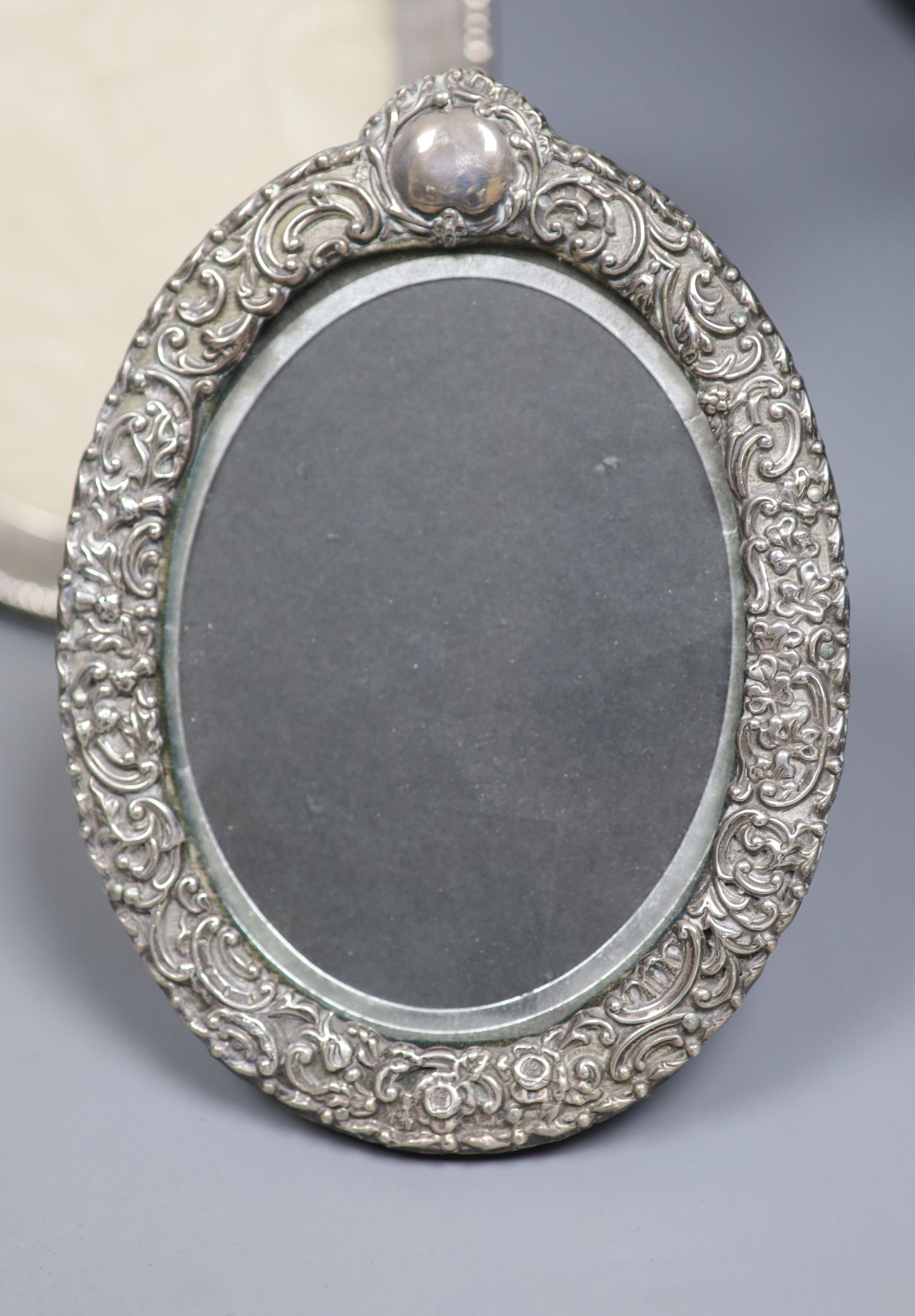 A George V oval silver photograph frame with reeded and beaded border, London 1910, 21.5cm and three other silver frames.